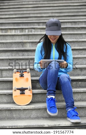 skateboarder woman use digital tablet sit on stairs