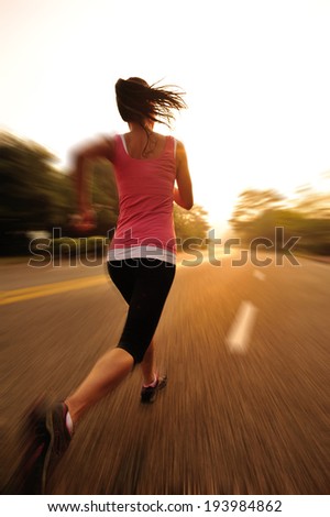 Runner athlete running on sunrise road. woman fitness jogging workout wellness concept.