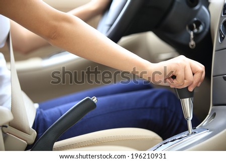 woman driver shifting the gear stick and driving a car