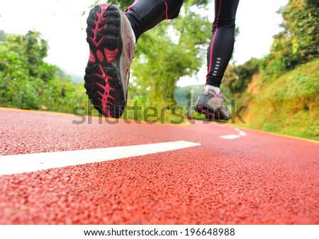 Runner athlete running on trail. woman fitness jogging workout wellness concept.