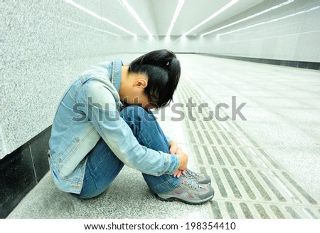 disappointed woman sit on the passage of subway station