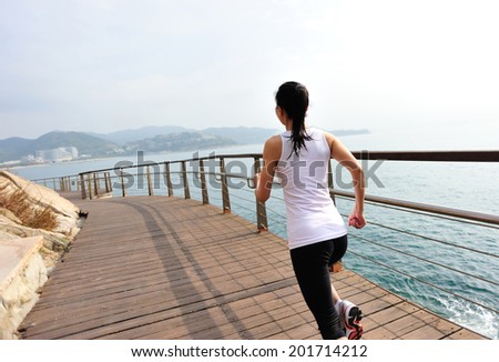 Runner athlete running on wooden deck. woman fitness sunrise jogging workout wellness concept.