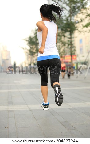 Runner athlete running on city street. woman fitness jogging workout wellness concept.