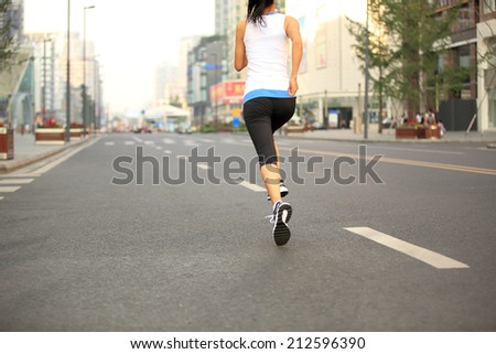 Runner athlete running on city road. woman fitness jogging workout wellness concept. unfocused
