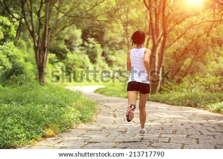 young fitness woman running at forest stone trail