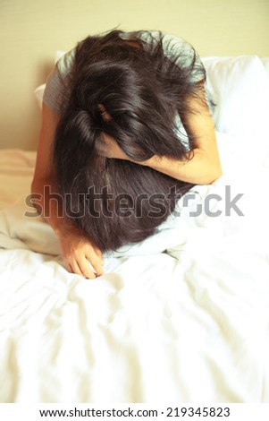 sad woman sit on bed