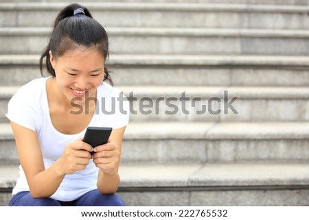 young woman use her cellphone sit on stairs