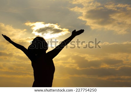 woman open arms under the sunrise at sea