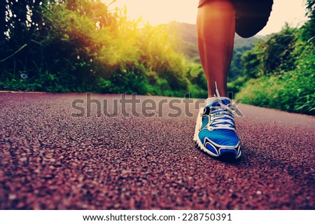 young fitness woman runner legs running at forest trail