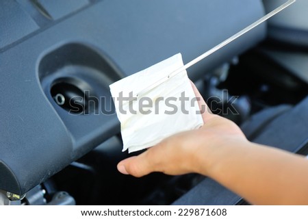 hands checking the car engine oil