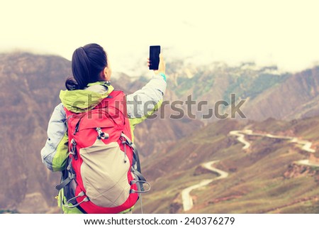 woman hiker taking photo at nujiang river 72 turn road, tibet,china