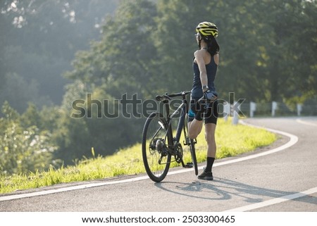 Similar – Image, Stock Photo Female cyclist stretching legs on street