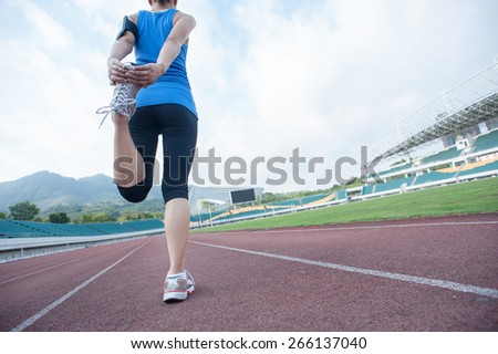 young fitness woman runner warm up before running on track