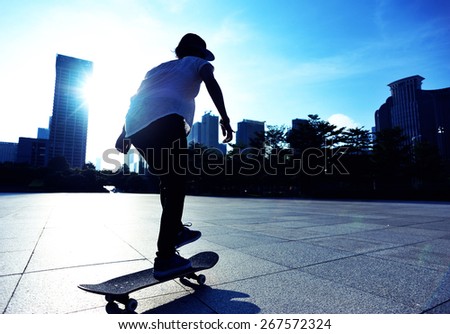 woman skateboarder legs skateboarding at sunrise city