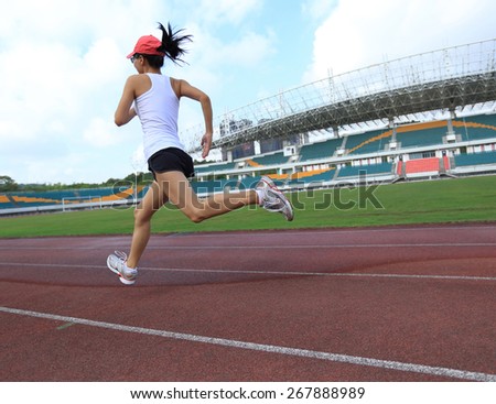 young fitness woman runner running on track