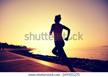 young woman runner running at seaside. woman fitness silhouette sunrise jogging workout wellness concept.