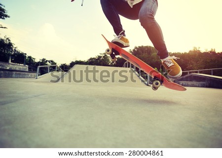 skateboarding legs doing trick ollie at skatepark