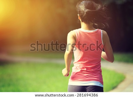 Runner athlete running at park trail. woman fitness jogging workout wellness concept.