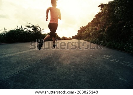 Runner athlete running at seaside road. woman fitness silhouette sunrise jogging workout wellness concept.