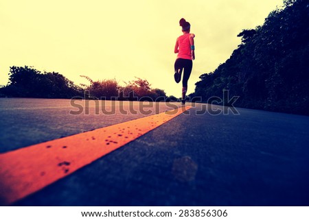Runner athlete running at seaside road. woman fitness jogging workout wellness concept.