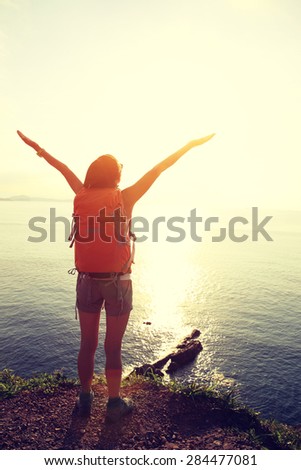 cheering woman backpacker on  seaside mountain  enjoy the view