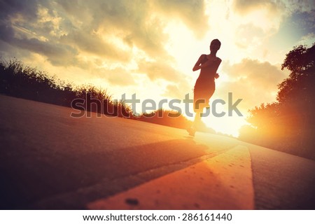 young fitness woman runner running on sunrise trail