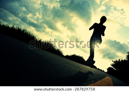 silhouette of fitness woman runner running at sunrise seaside trail,vintage effect