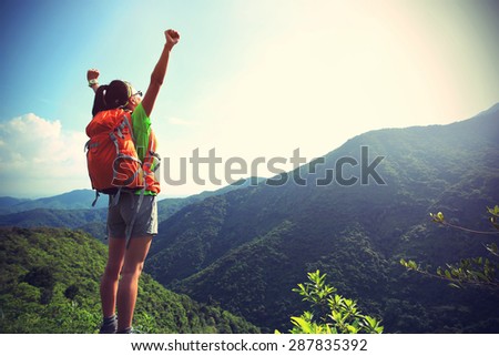 cheering woman hiker at mountain peak,vintage effect