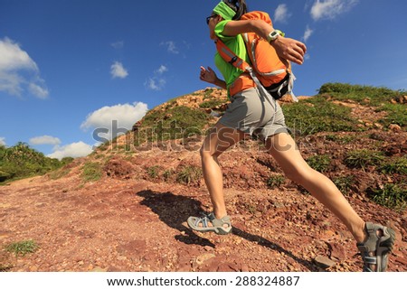 young woman backpacker running on  seaside mountain trail