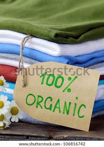 stack of colorful clothing with organic label and flowers