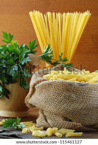 Linen bag of pasta (penne) on a wooden table