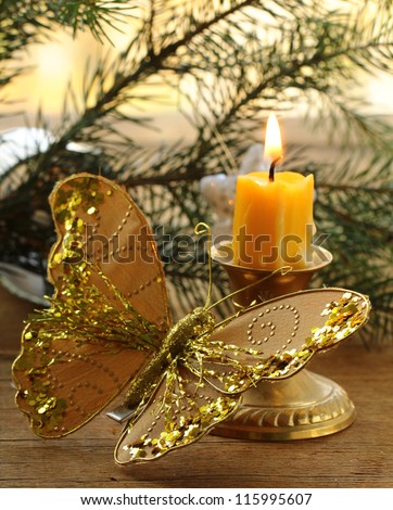 Christmas decoration - fir branches, candles and gold butterfly