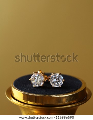 gold earrings stud  with diamonds  on gold background