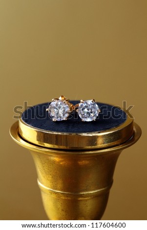 gold earrings stud  with diamonds  on gold background