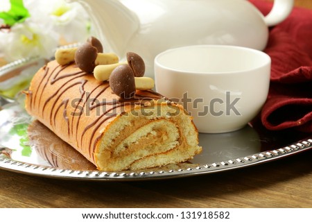 Sweet cake roll with coffee cream garnished with sweet mushrooms