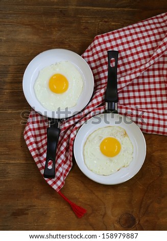 Two pan with fried eggs - breakfast for couples