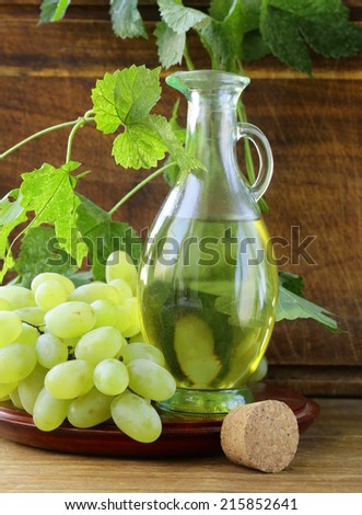 jugful with grape seed oil on a wooden table