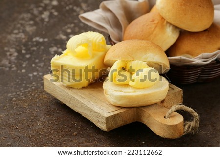 yellow dairy butter on a fresh bun bread for breakfast
