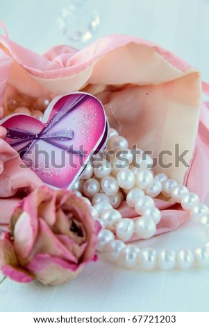 white pearls in a pink bag with a rose romantic concept