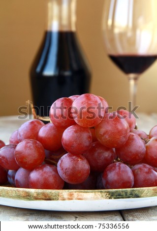 large red ripe grapes and wine on the natural background
