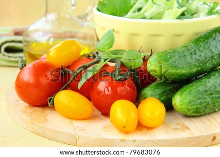ingredients for the salad, cucumbers, tomatoes, olive oil and green salad mix