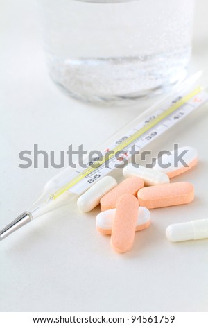 Electronic thermometer, pills  and glass with water