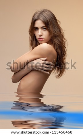 beautiful topless woman with long hair in water