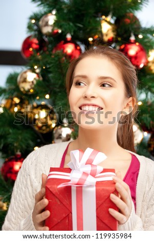bright picture of happy woman with gift box and christmas tree......