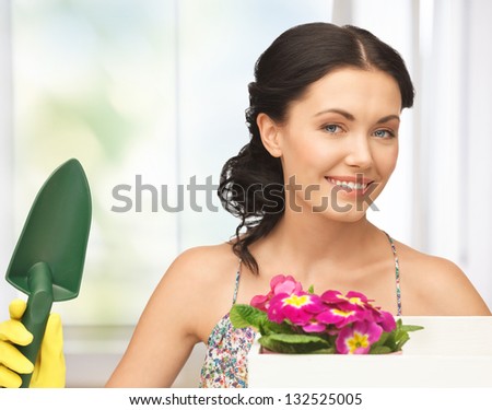 lovely housewife with flower in box and gardening trowel