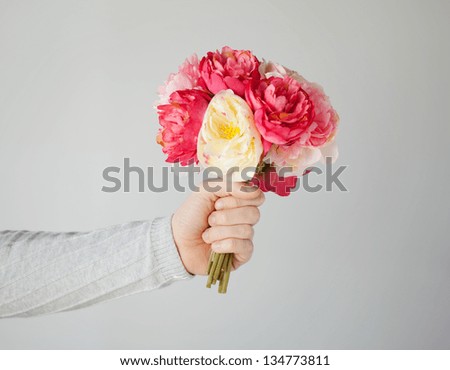 close up of man\'s hand giving bouquet of flowers.