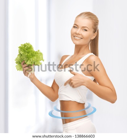 picture of beautiful sporty woman with lettuce showing abs
