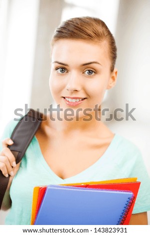happy student girl with school bag and color folders