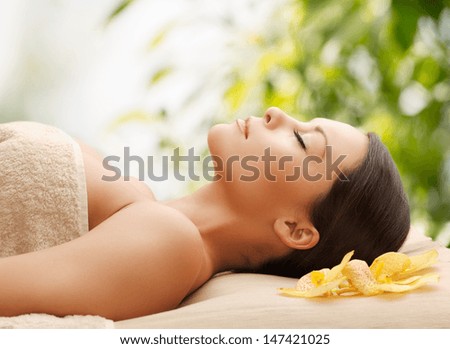spa and holidays concept - woman in spa lying on the massage desk