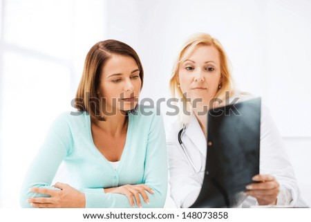 healthcare, medical and radiology concept - doctor with patient looking at x-ray